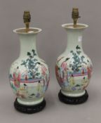 A pair of 20th century Chinese porcelain vases painted with figures, etc., converted to lamps.