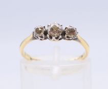 An 18 ct gold and platinum three-stone diamond ring. Ring size L/M.