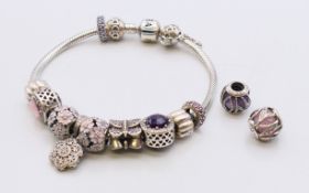 A boxed Pandora bracelet with charms. 6.5 cm inner diameter.