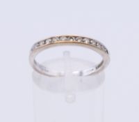 An 18 K white gold diamond half hoop eternity ring. Ring size P.