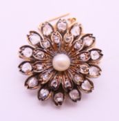 An unmarked gold diamond and pearl set pendant/brooch. 3 cm diameter.