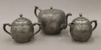 A Chinese three-piece pewter tea set. The teapot 24 cm long.