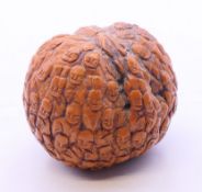 A Chinese carved walnut, decorated with figures. 4 cm wide.