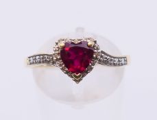 A 9 ct gold diamond and red stone heart-shaped ring. Ring size S.