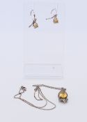 A citrine set silver pendant on chain and a pair of earrings. The pendant 2.5 cm high.