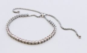 A diamond set adjustable silver bracelet. 26 cm maximum length.