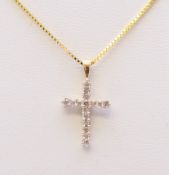 A 14 ct gold diamond cross pendant on a silver gilt chain. The pendant 2 cm high.