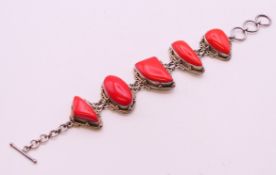 A silver and coral bracelet, 18 cm long.