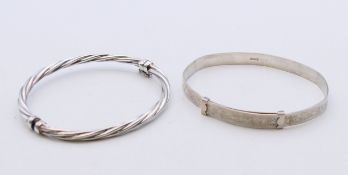 Two silver bangles. The largest 6 cm inner diameter.