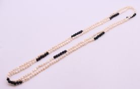 An Art Deco style pearl and black glass bead necklace, 154 cm long.