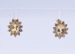 A pair of diamond and citrine ear studs, each 1.2 cm high.