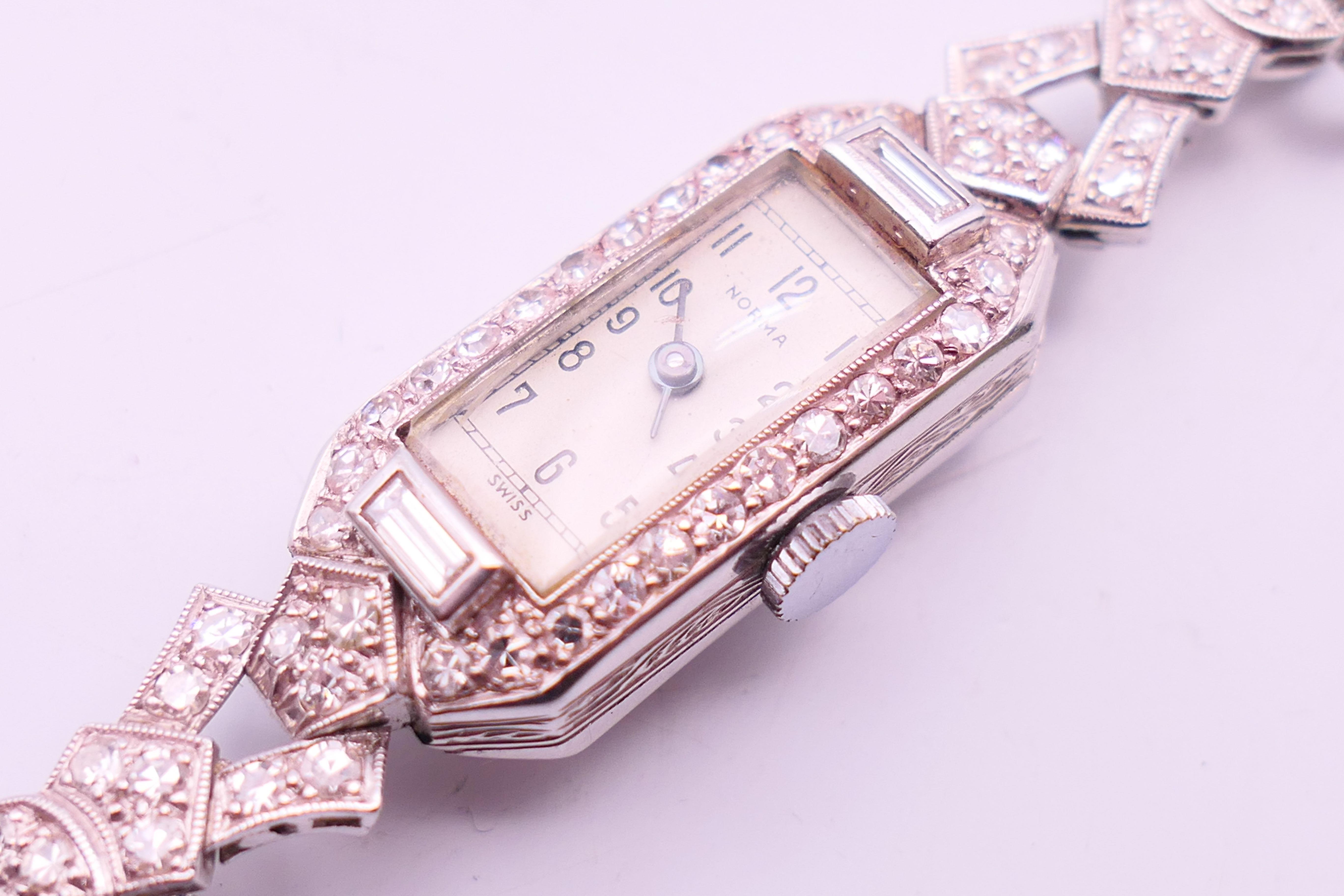 An early 20th century 9 ct white gold and diamond cocktail wristwatch and strap. 1.5 cm wide. - Image 3 of 6