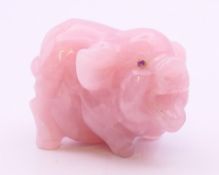 A rose quartz model of a pig with gold and ruby eyes. 6.5 cm long.