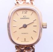 A Garrards 9 ct gold ladies wristwatch. 1.5 cm wide. 22.9 grammes total weight.