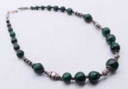 A white metal and malachite necklace. 51 cm long.