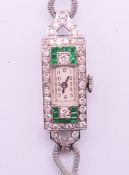 A boxed 9 ct white gold diamond and emerald cocktail wristwatch. 1.2 cm wide. 14.