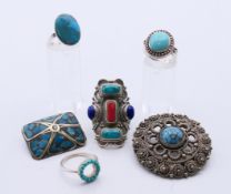Various turquoise set jewellery to include two brooches and four rings. The largest 4.5 cm diameter.