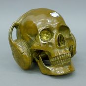 A bronze skull with headphones. 15 cm high.