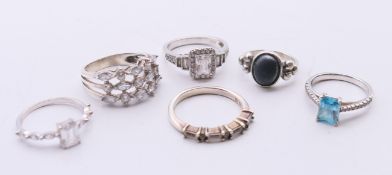 Six silver dress rings.