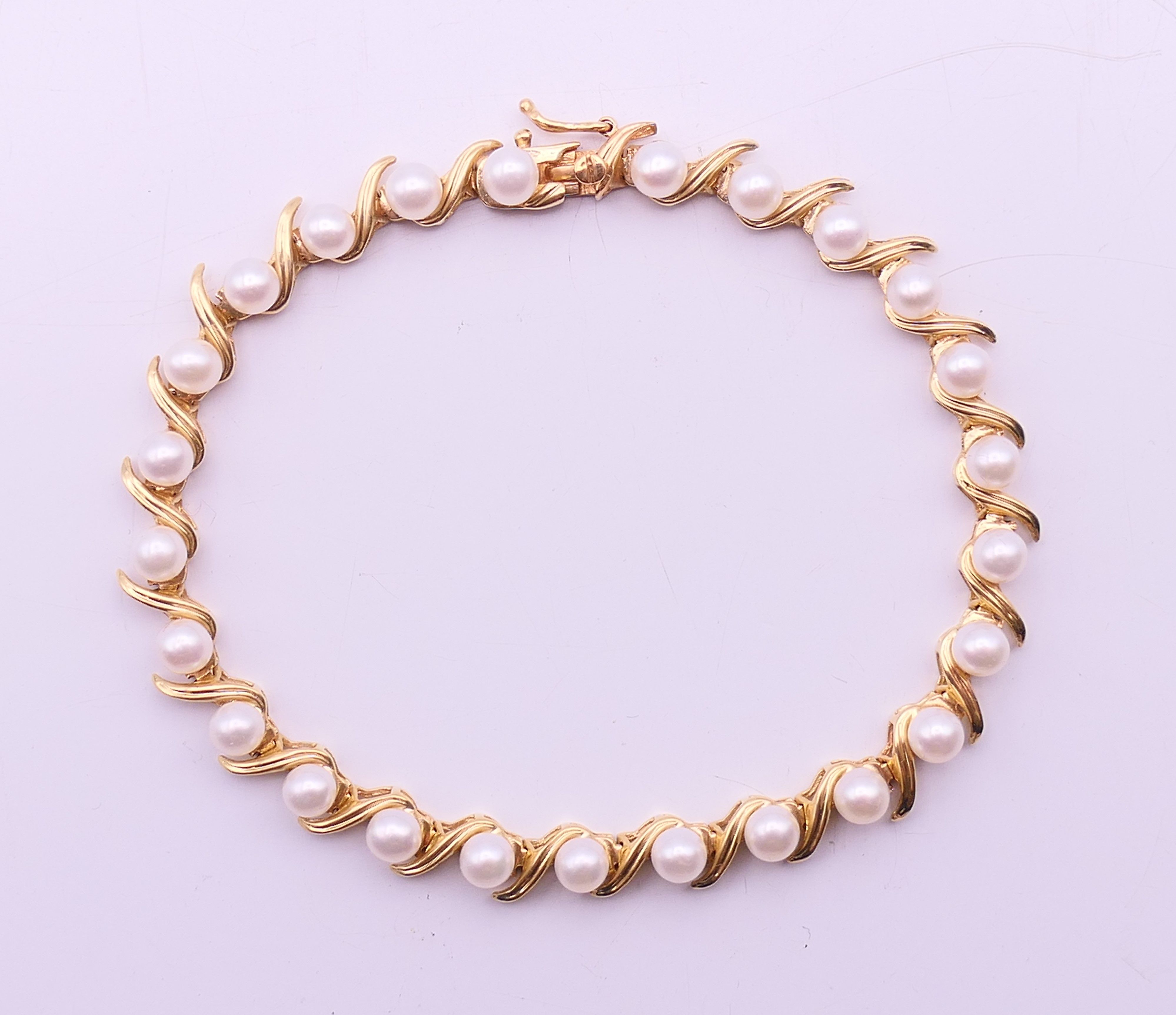 A 14 ct gold and pearl bracelet. 18 cm long. 10 grammes total weight.