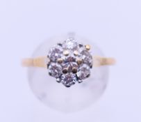 A gold and diamond flowerhead ring. Ring size Q.