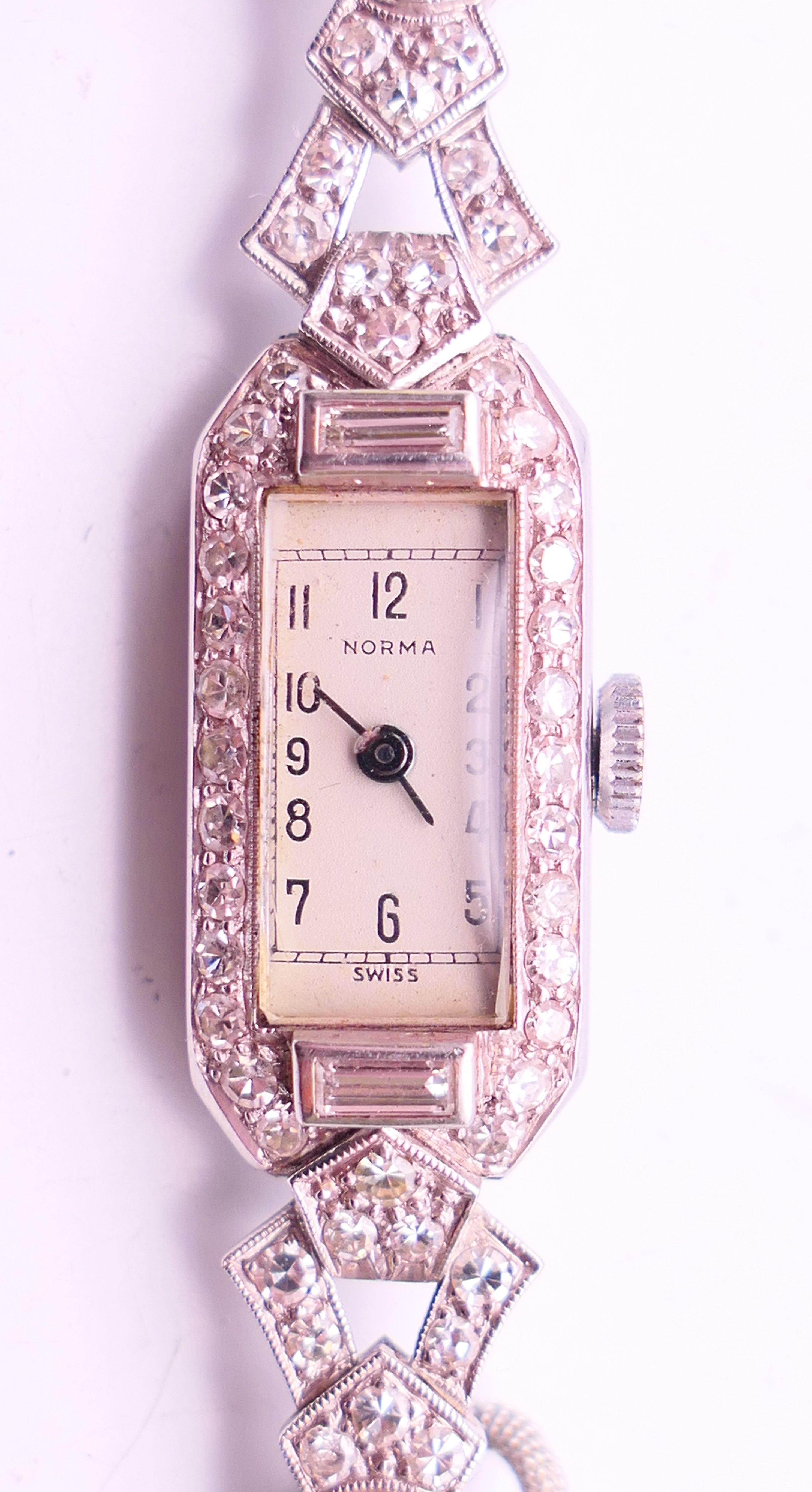 An early 20th century 9 ct white gold and diamond cocktail wristwatch and strap. 1.5 cm wide.