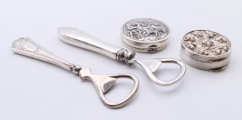 Two silver pill boxes and two silver-handled bottle openers. The largest 13.5 cm long.