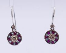 A pair of diamond and gem-set earrings, the brilliant-cut diamond collet,