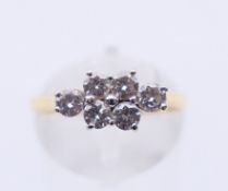 An 18 ct gold six-stone diamond ring. Ring size N.