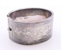 A silver engraved bangle. 6 cm inner diameter. 53.7 grammes.