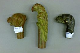 Three bronze walking stick tops. The largest 13 cm high.