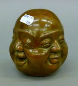 A brass four-faced Buddha head. 11 cm high.