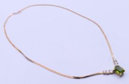 A 9 ct gold necklace set with a peridot and clear stones. 40 cm long. 6.7 grammes total weight.