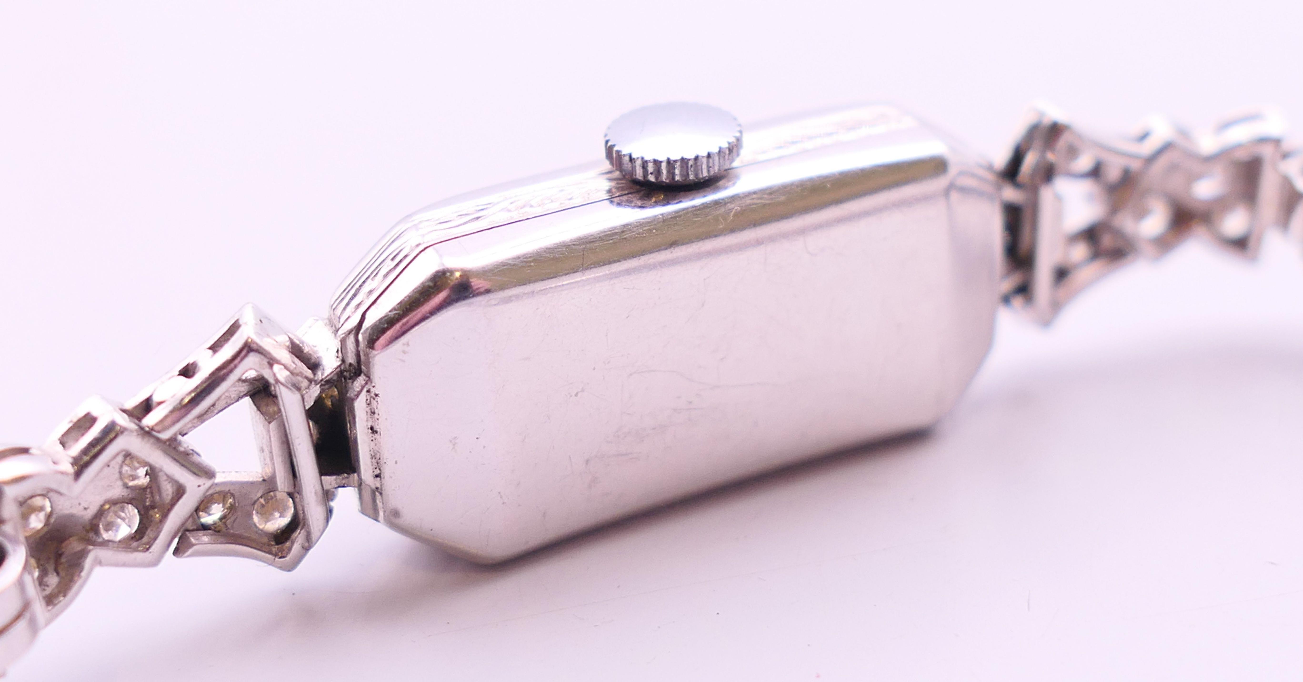 An early 20th century 9 ct white gold and diamond cocktail wristwatch and strap. 1.5 cm wide. - Image 5 of 6