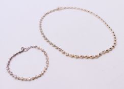 A silver dress necklace 43 cm long and a matching bracelet 17 cm long.