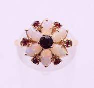 A 9 ct gold opal and garnet flowerhead ring. Ring size N/O.