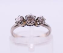 An 18 ct white gold three-stone diamond ring. Ring size H/I.