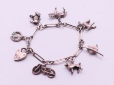 A silver charm bracelet. 16 cm long. 23.6 grammes.
