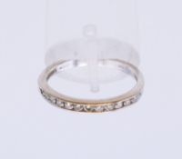 An 18 K white gold diamond half hoop eternity ring. Ring size P.
