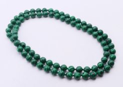 A string of malachite beads. 90 cm long.