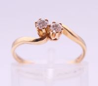 A 9 ct gold two stone diamond crossover ring. Ring size K/L.