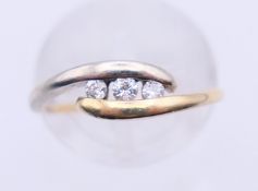 A 9 ct bi-gold three-stone diamond ring. Ring size K/L.