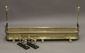 A 19th century brass fender and a pair of fire dogs. 120 cm wide.