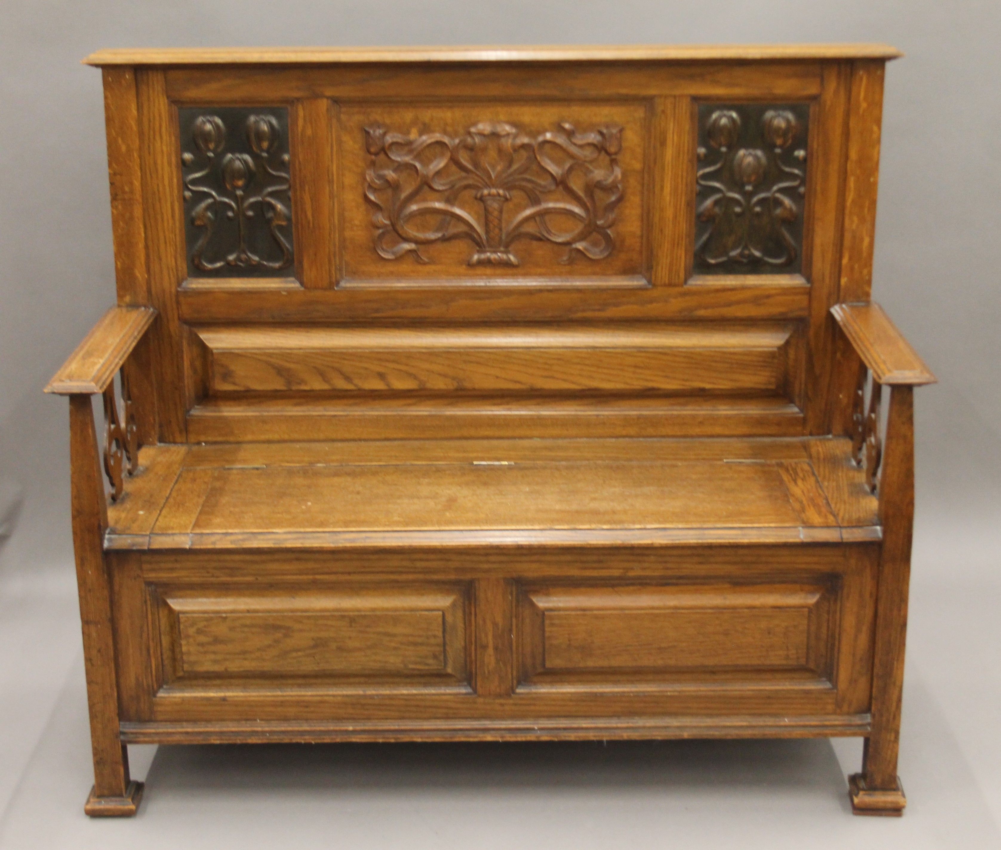 An Arts and Crafts oak box settle. 126.5 cm wide, 110 cm high, 47 cm deep.