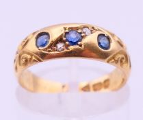 An 18 ct gold sapphire and diamond gypsy ring. Ring size L.