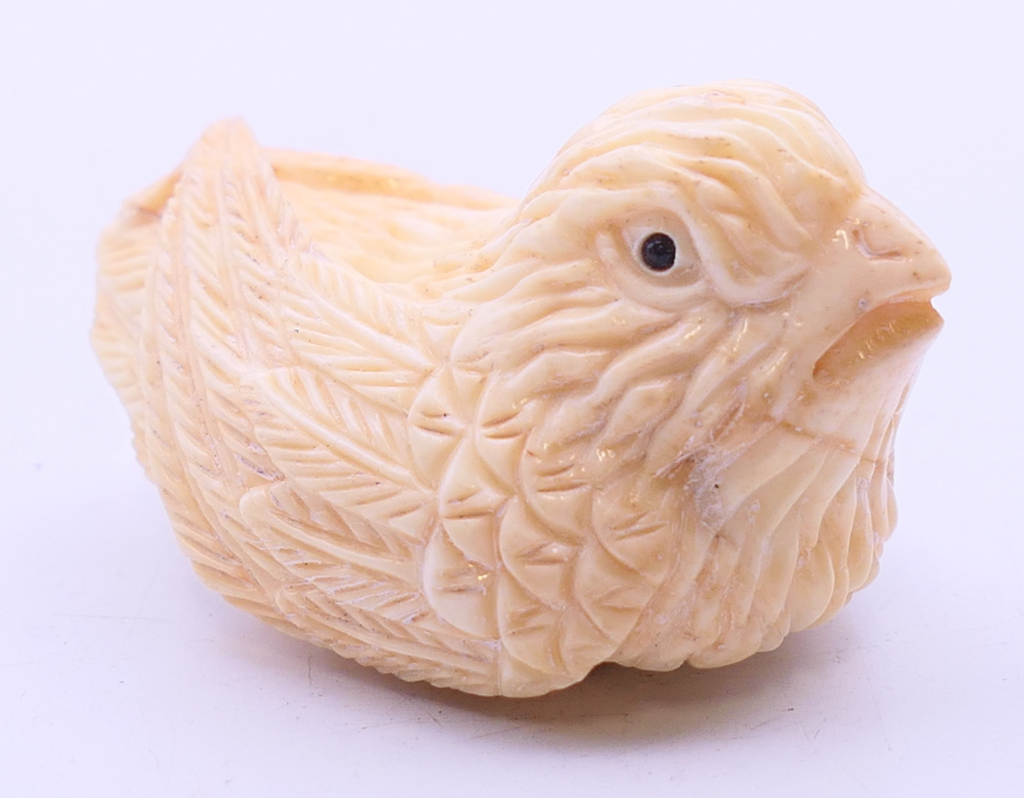 A bone netsuke formed as a chicken. 4.5 cm wide.