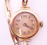 A 9 ct gold ladies wristwatch. 2.5 cm diameter. 14.8 grammes total weight.