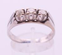 A 14 ct white gold three-stone diamond ring. Ring size Q/R.