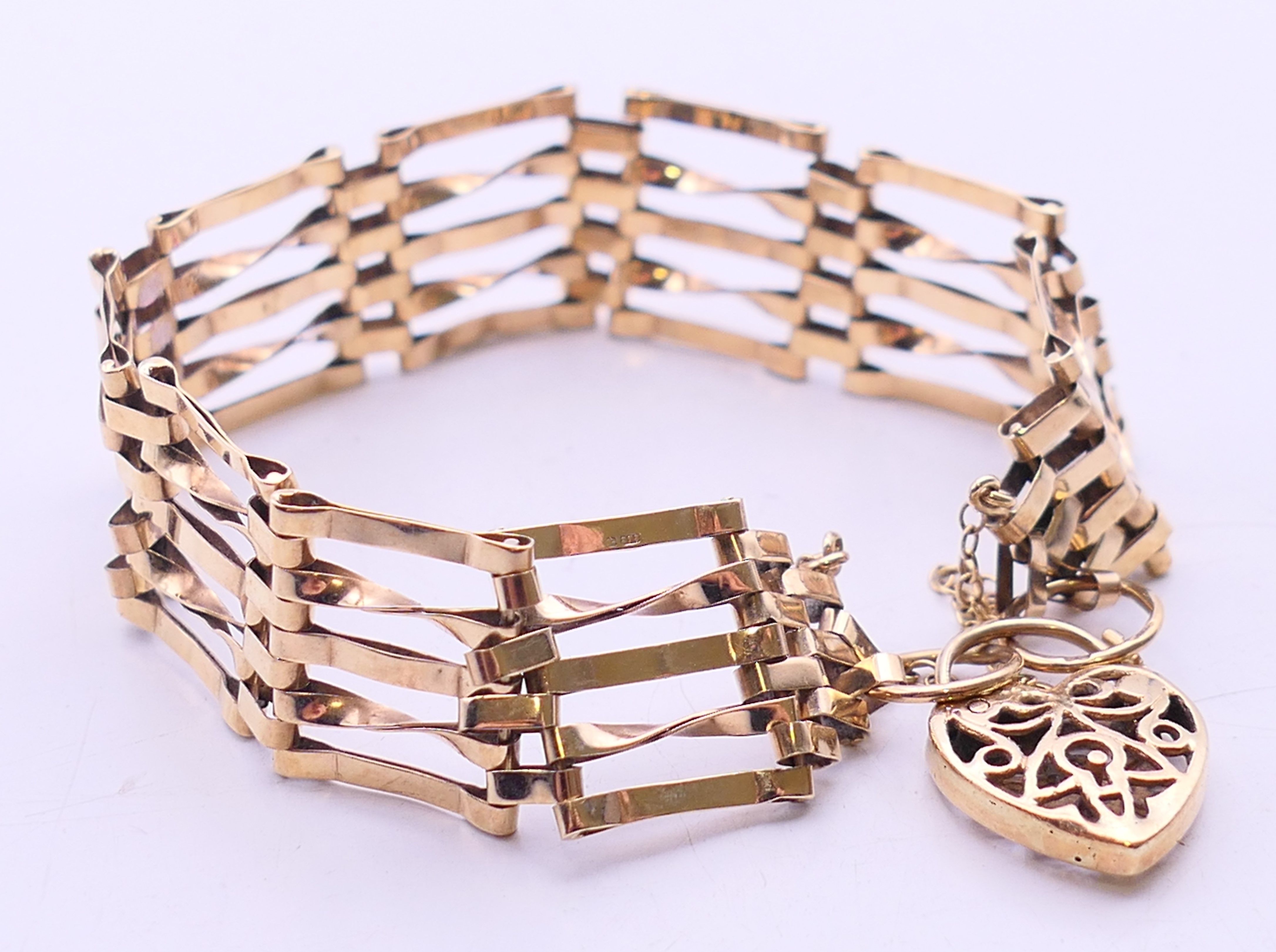 A 9 ct gold gate link bracelet with heart padlock. 18 cm long. 12.