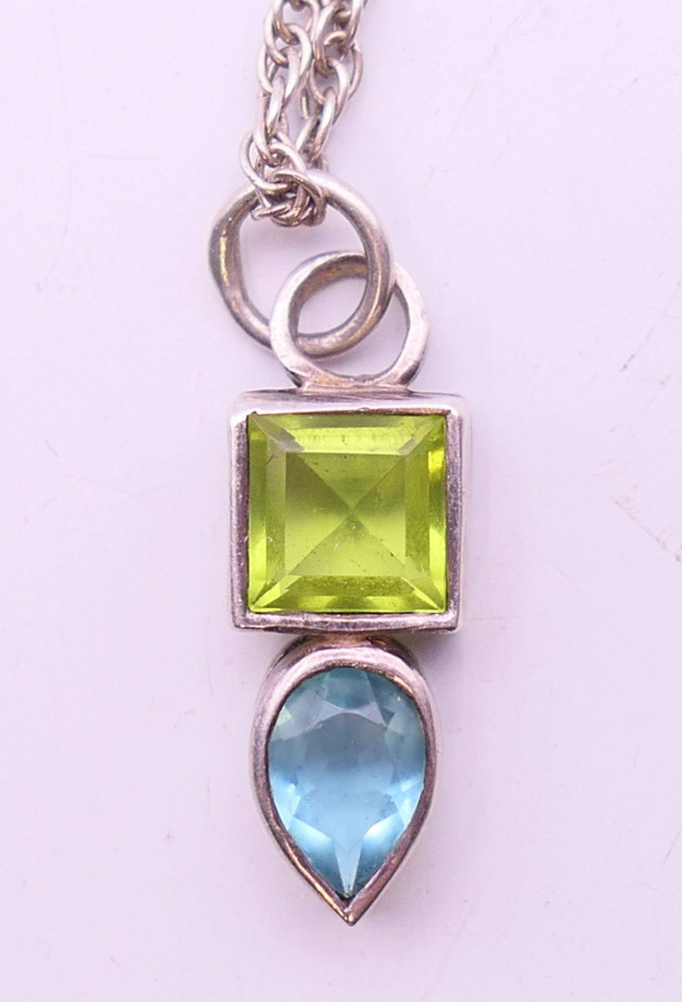 A silver peridot and blue topaz pendant and chain. Pendant 2 cm high, chain 40 cm long. - Image 2 of 5